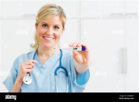 Female nurse holding thermometer Stock Photo - Alamy