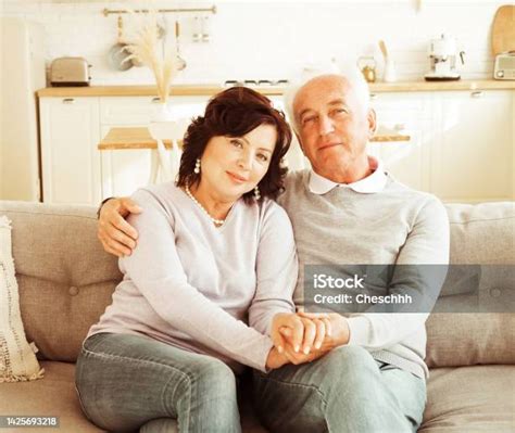 Mature 60 Year Old Couple Hugging While Sitting On Sofa Love Forever