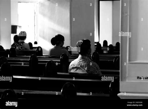 BAGUIO, PHILIPPINES - Dec 21, 2016: A grayscale host of Filipino Catholics inside the Baguio ...