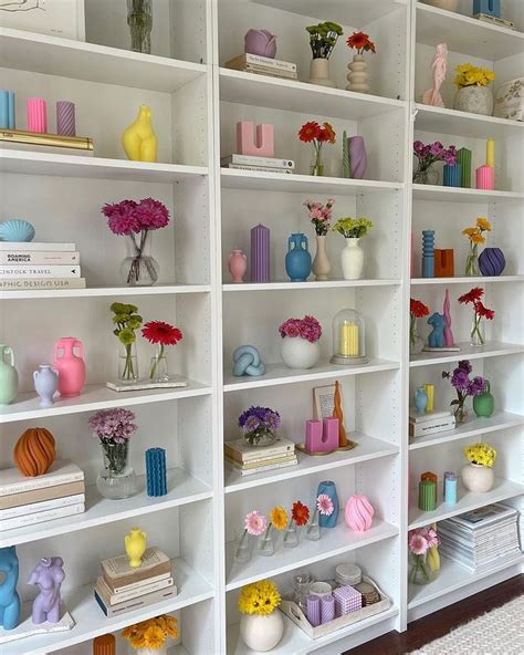 A White Bookcase Filled With Lots Of Colorful Vases And Flowers