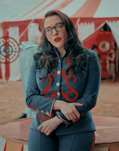 A Woman Sitting On Top Of A Wooden Table Next To A Tent With Circus