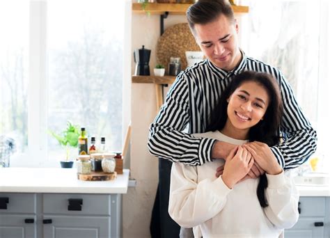 Junges Paar in der Küche sitzen und kuscheln Kostenlose Foto