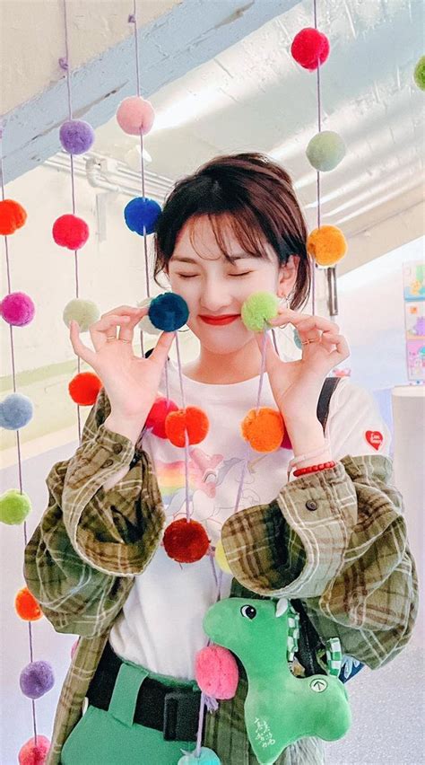 A Woman Holding Up Several Colorful Balls In Front Of Her Face