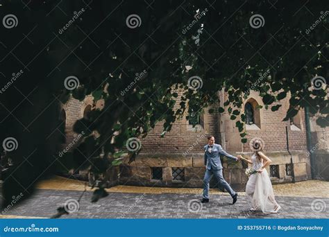 Stylish Happy Bride And Groom Running And Smiling On Background Of