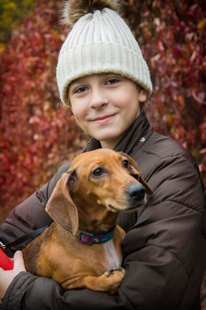 Dans Le Parc Une Fille Tient Un Chien Teckel Dans Ses Bras Photo Premium