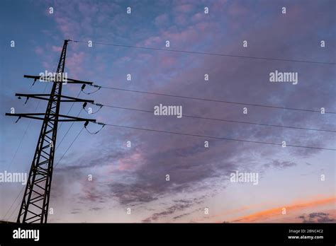 Power Transmission Pylon And Wires Against The Sky With Orange And Dark