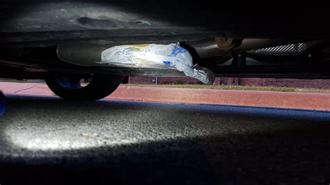 bag stuck under middle of car