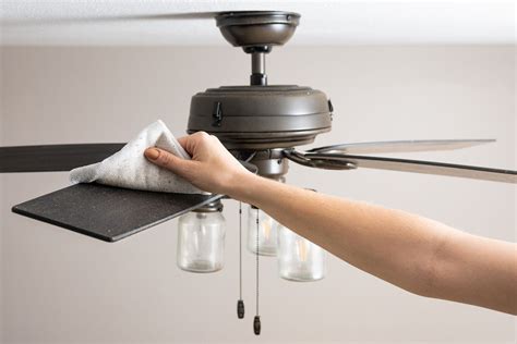 Various ceiling fan blade materials shown during cleaning process with tools