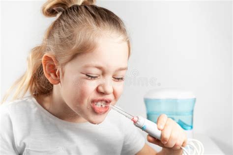 child using water flosser to clean back molars