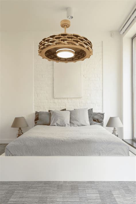 A elegant fandelier providing soft light and gentle breeze in a cozy bedroom setting