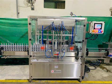 Liquid packing machine filling bottles on a production line